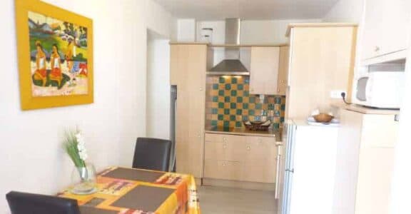 Amelie les bains location daviaud, photo de la cuisine avec table pour manger du studio n°C8 avec balcon donnant sur la rue Castellane. Cette location se trouve à 100 mètres des thermes.