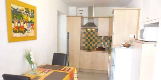 Amelie les bains location daviaud, photo de la cuisine avec table pour manger du studio n°C8 avec balcon donnant sur la rue Castellane. Cette location se trouve à 100 mètres des thermes.